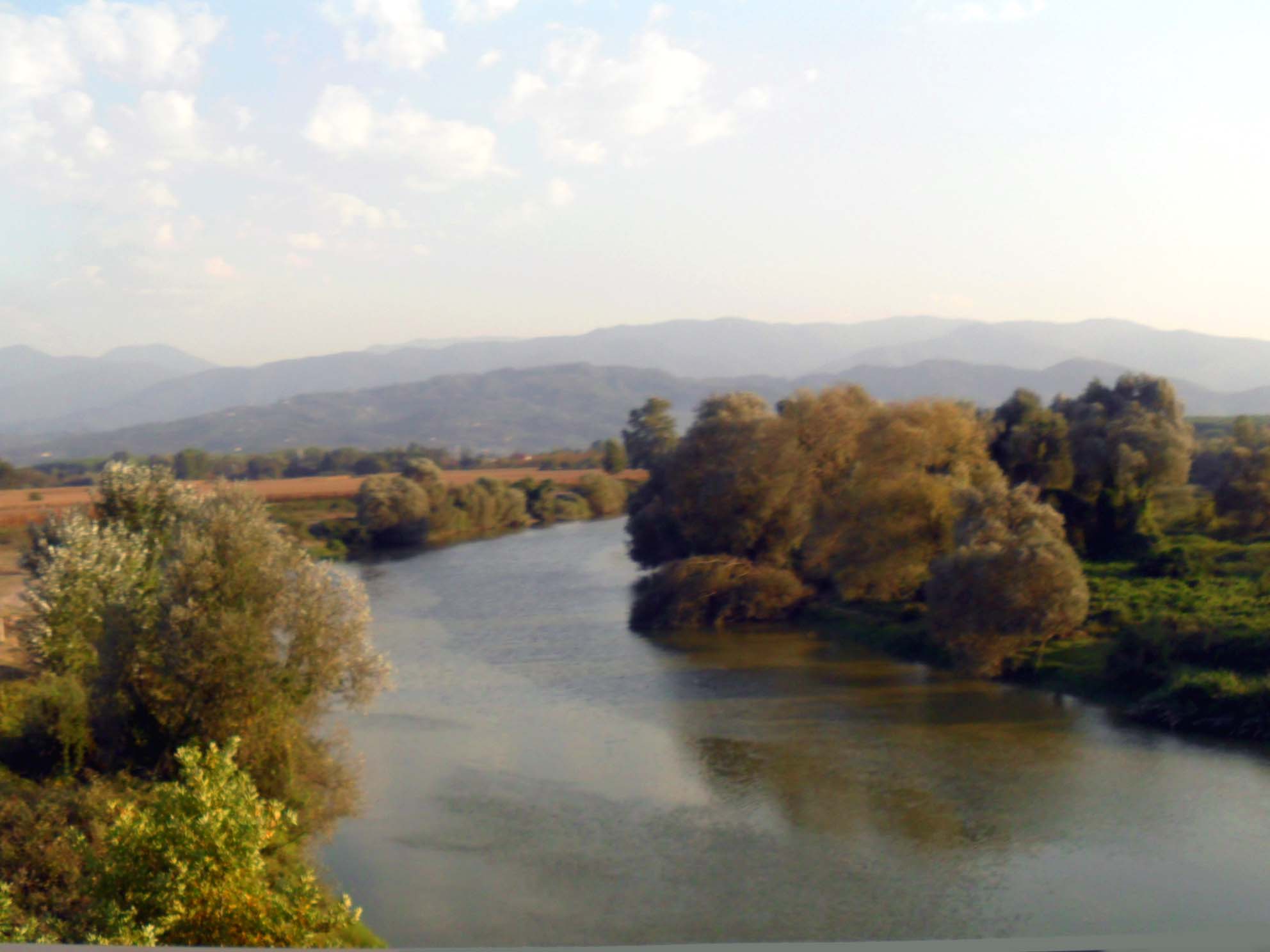 The Sakarya River winding through a valley with autumn-tinted trees and hazy mountains in the background