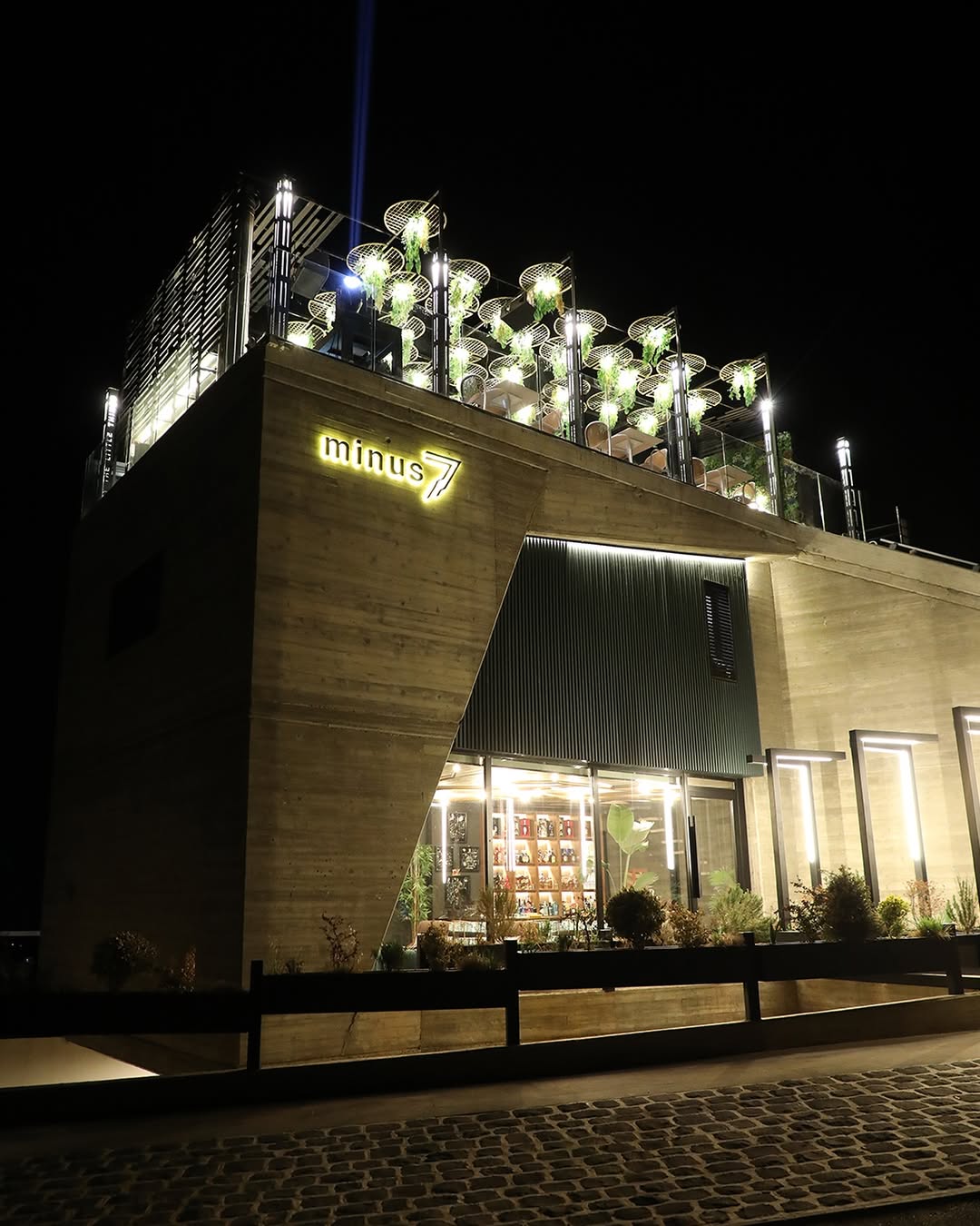 Minus7 boutique retreat exterior at night with illuminated neon signage
