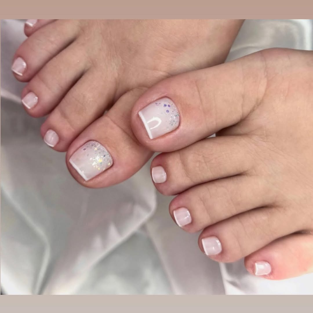 Unhas dos pés ombré branco com glitter iridescente