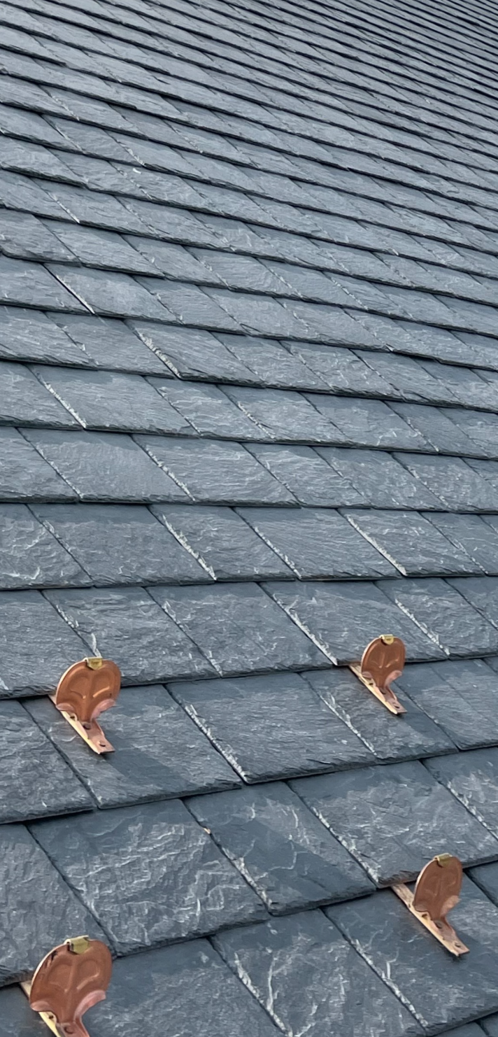 Detailed slate roofing with copper snow guards