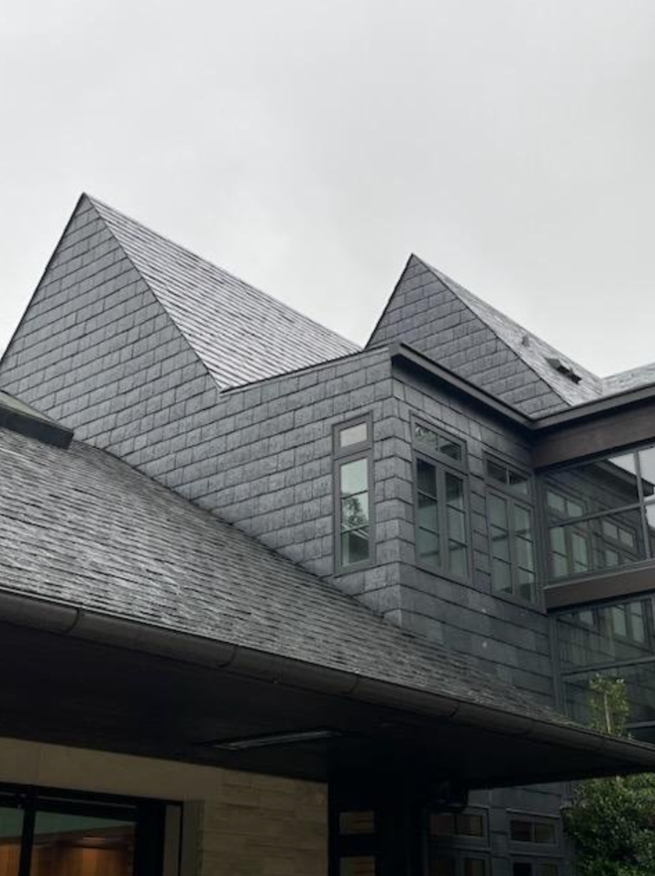 Professional roofers working on a slate roof installation