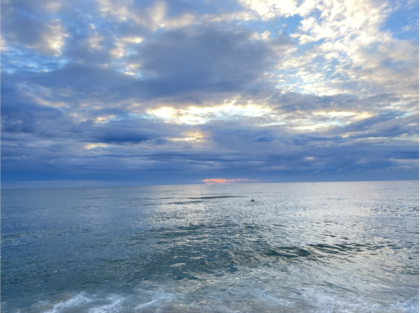 Ocean view with dramatic cloudy sky and sunlight