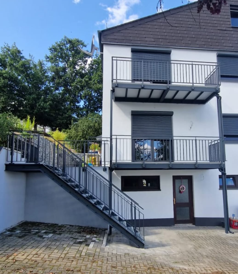 Außentreppe Stahl mit Balkon und Geländer am Mehrfamilienhaus