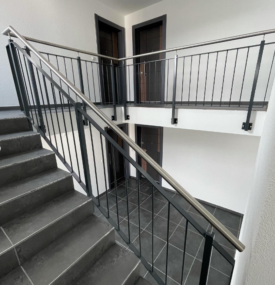 Treppengeländer Mehrfamilienhaus fertiggestellt mit dunklen Fliesen