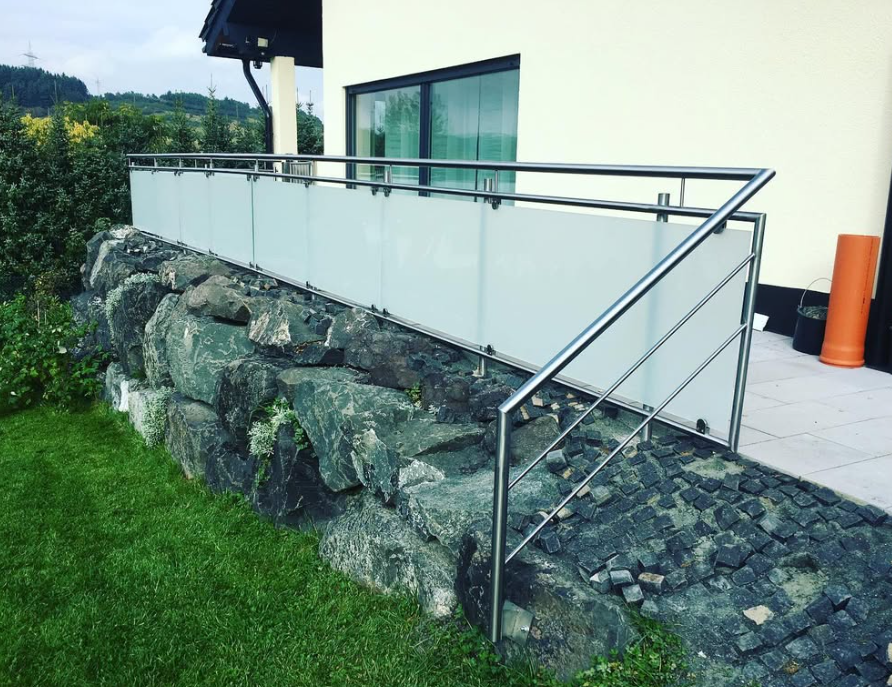 Terrassengeländer Edelstahl mit Glasfüllung und Natursteinmauer