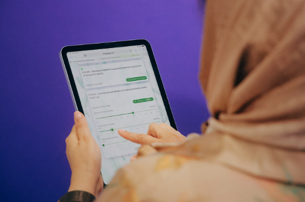 A judge scoring a submission using the InstaJudge slider interface on an iPad at RCOG 2025