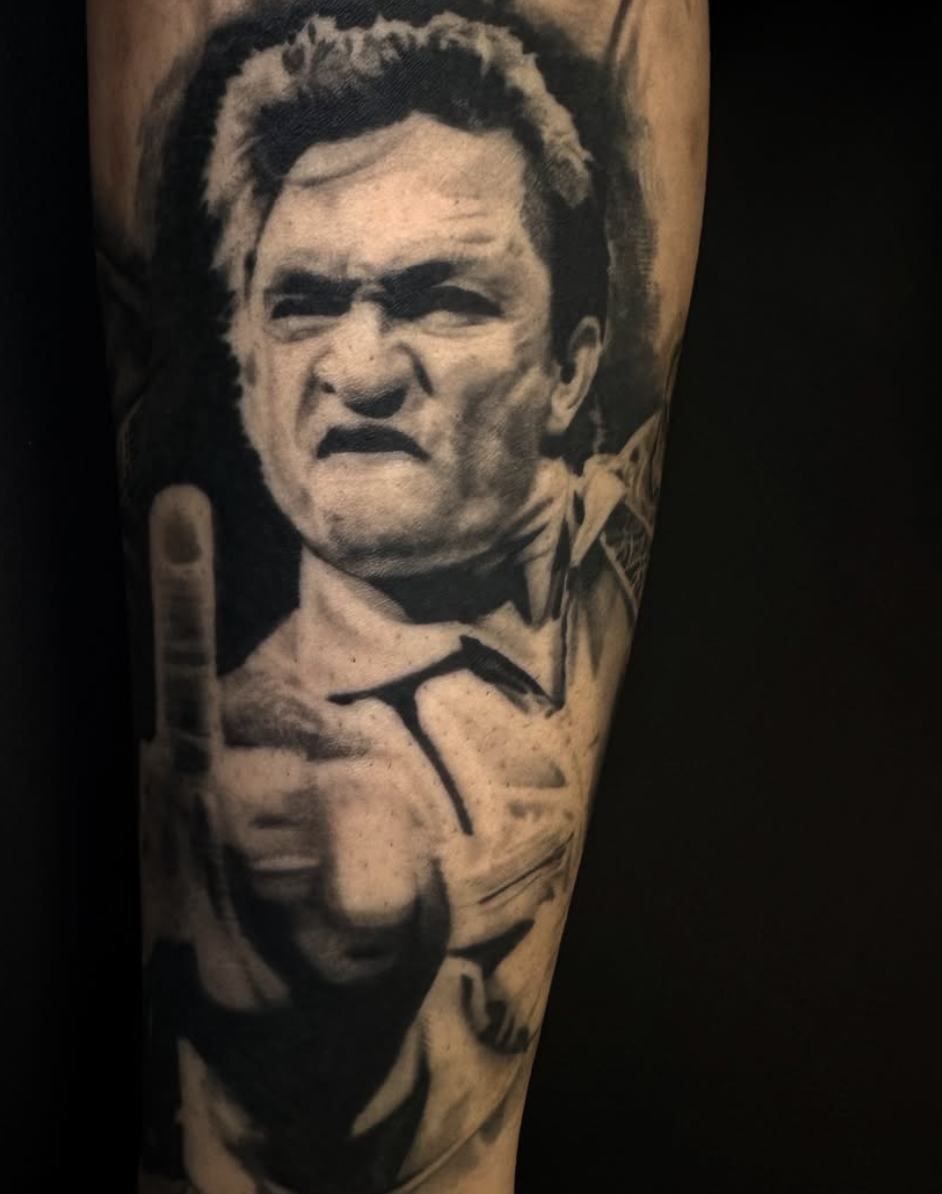 Johnny Cash portrait tattoo with middle finger gesture