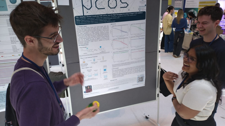 A presenter explaining their research poster to a visitor at the Life Science PhD Meeting 2026