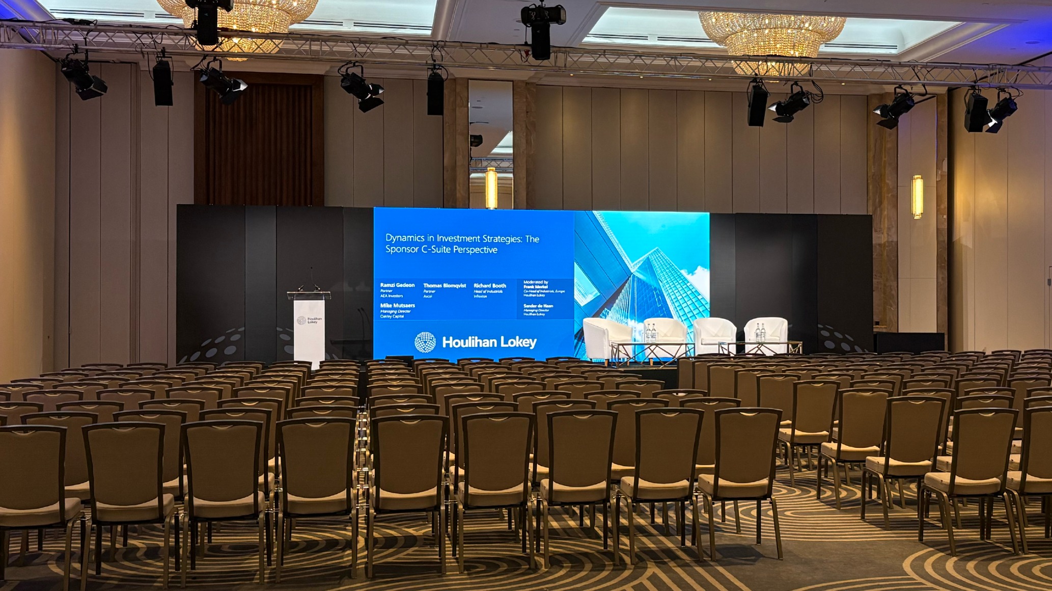 Conference room stage setup with panel discussion slide