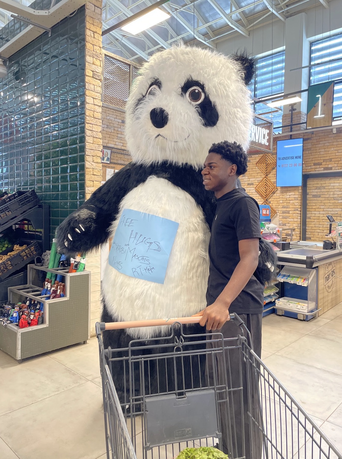 Panda mascot with a young man at a supermarket checkout