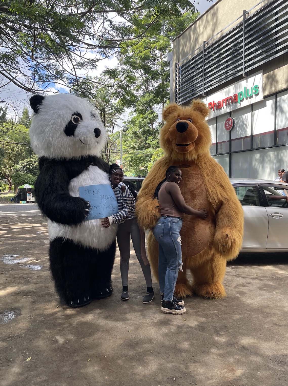 Mascots hugging guests outside Pharmaplus Nairobi