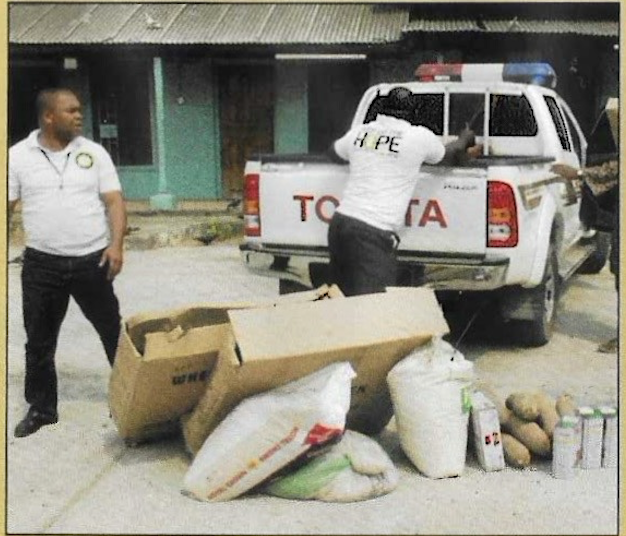KUTH volunteers offloading rice, yams, and provisions from the pickup