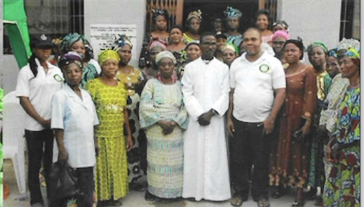 KUTH staff and a priest with widow beneficiaries