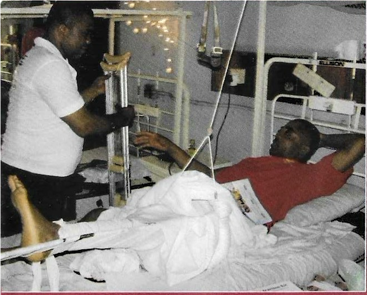 Volunteer handing crutches to patient with leg in traction