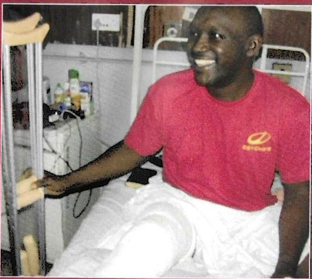 Smiling patient in red shirt holding crutches with joy