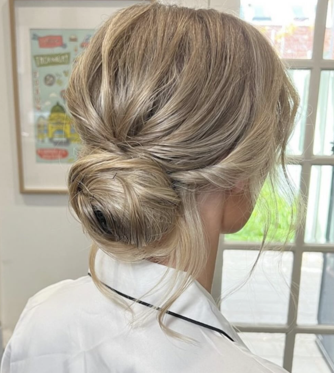 Back view of a soft textured blonde low-bun bridal updo