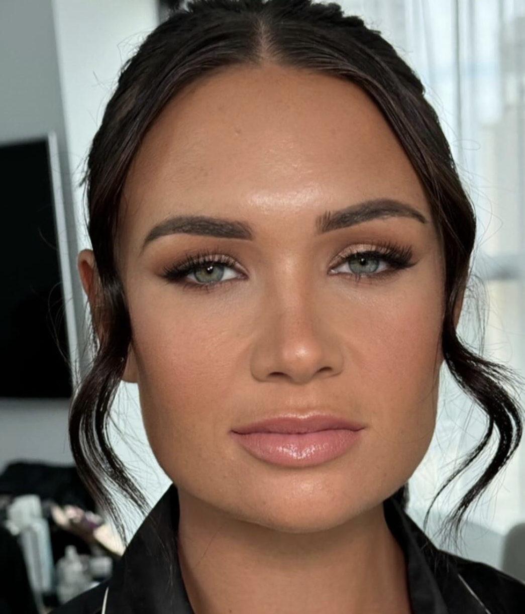 Brunette bride with bronzed soft glam, smokey eyes and a glossy nude lip with slicked-back waves
