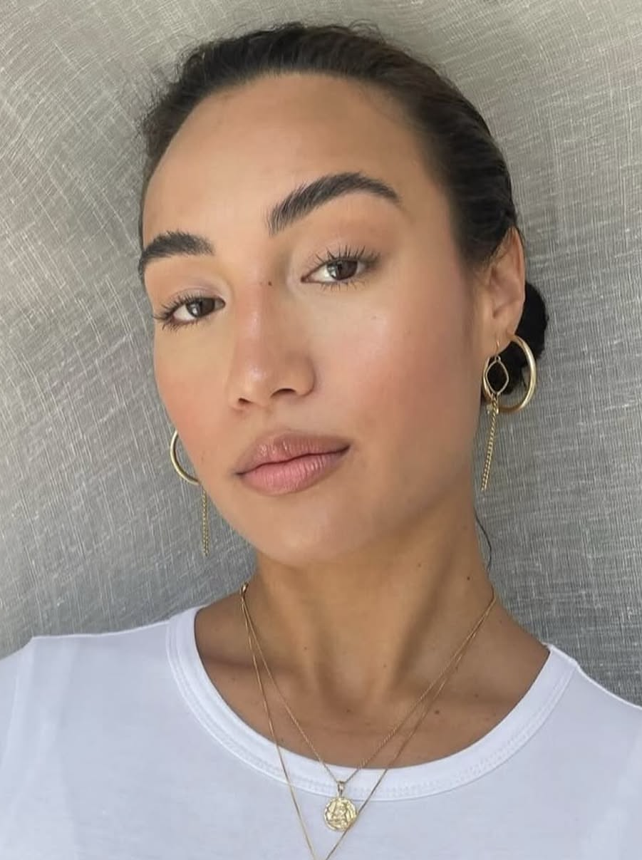 Client with sleek hair, natural dewy glam and gold hoop earrings