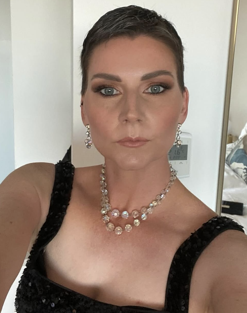 Client with a pixie cut, bronze glam and crystal jewellery in a black sequin dress