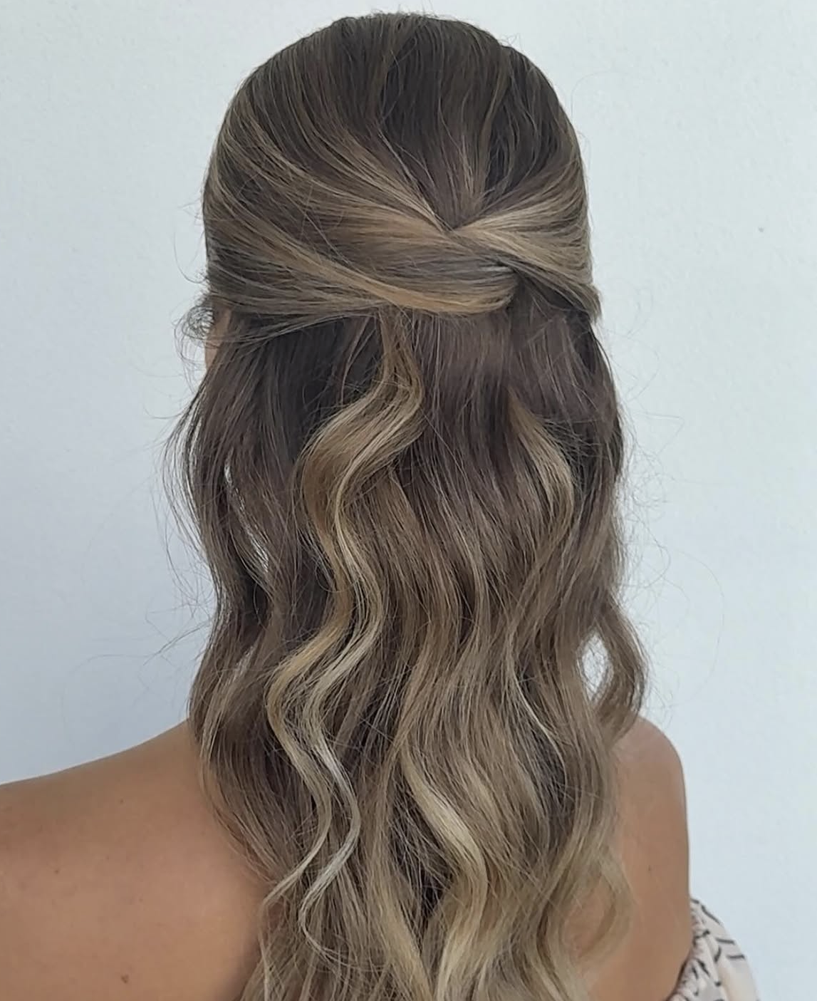 Back view of a half-up half-down wavy balayage style