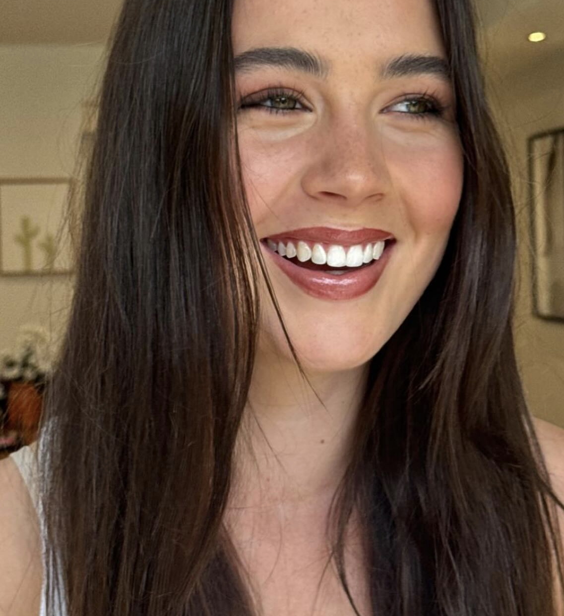 Brunette client laughing with natural glam and a berry gloss