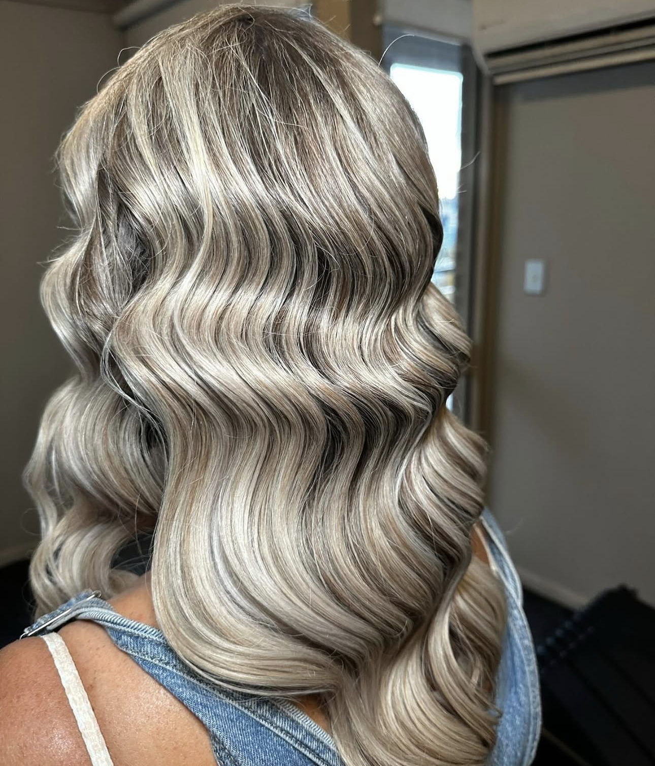 Back view of glossy ash-blonde Hollywood waves
