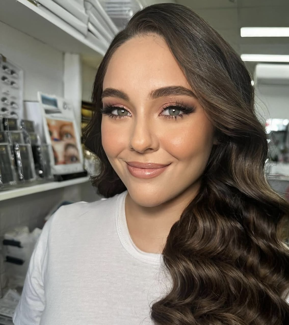 Brunette client with bronze glam and glossy Hollywood waves