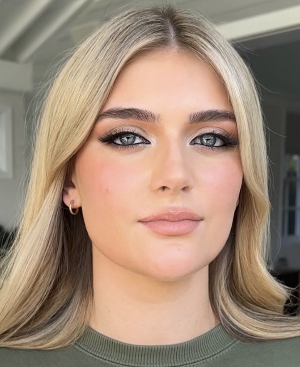 Blonde client with smokey bronze eyes, lashes and sleek styled hair