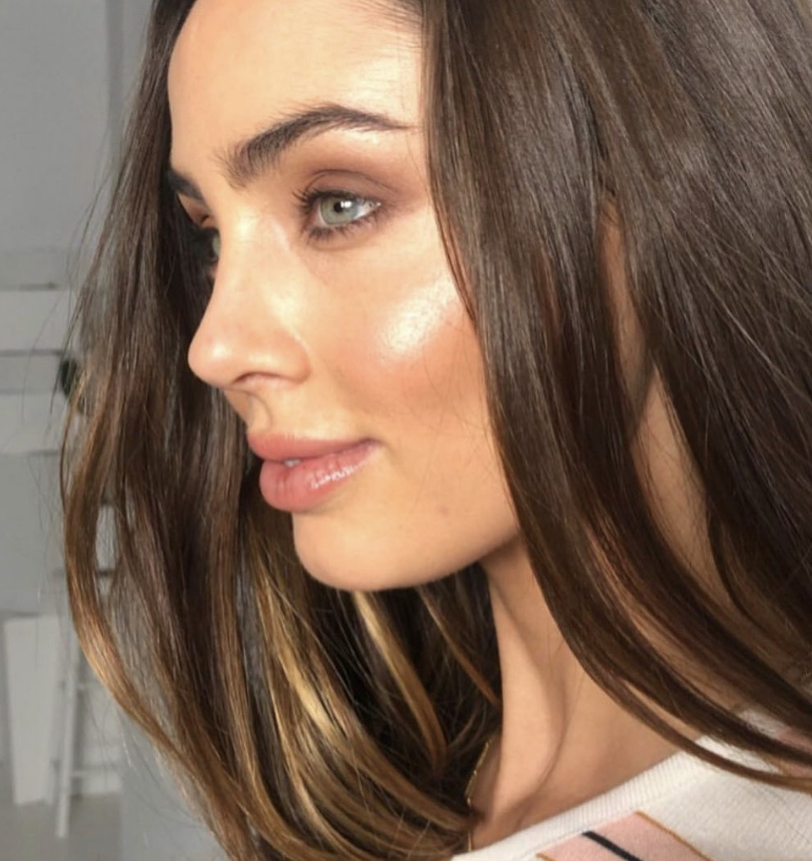 Side-profile beauty look with dewy glowing skin and soft glam