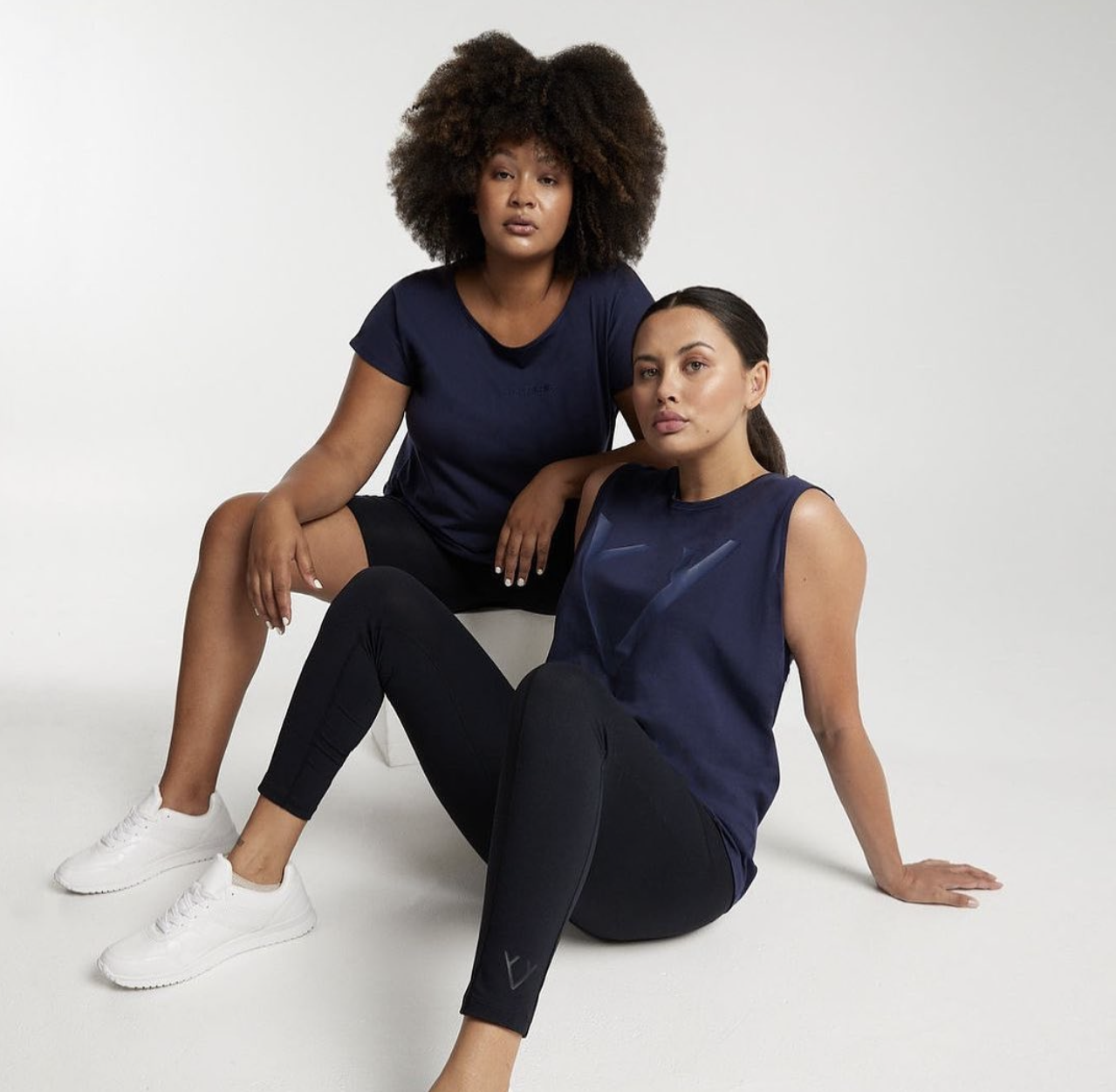 Activewear campaign shoot with two models in navy on a white studio backdrop