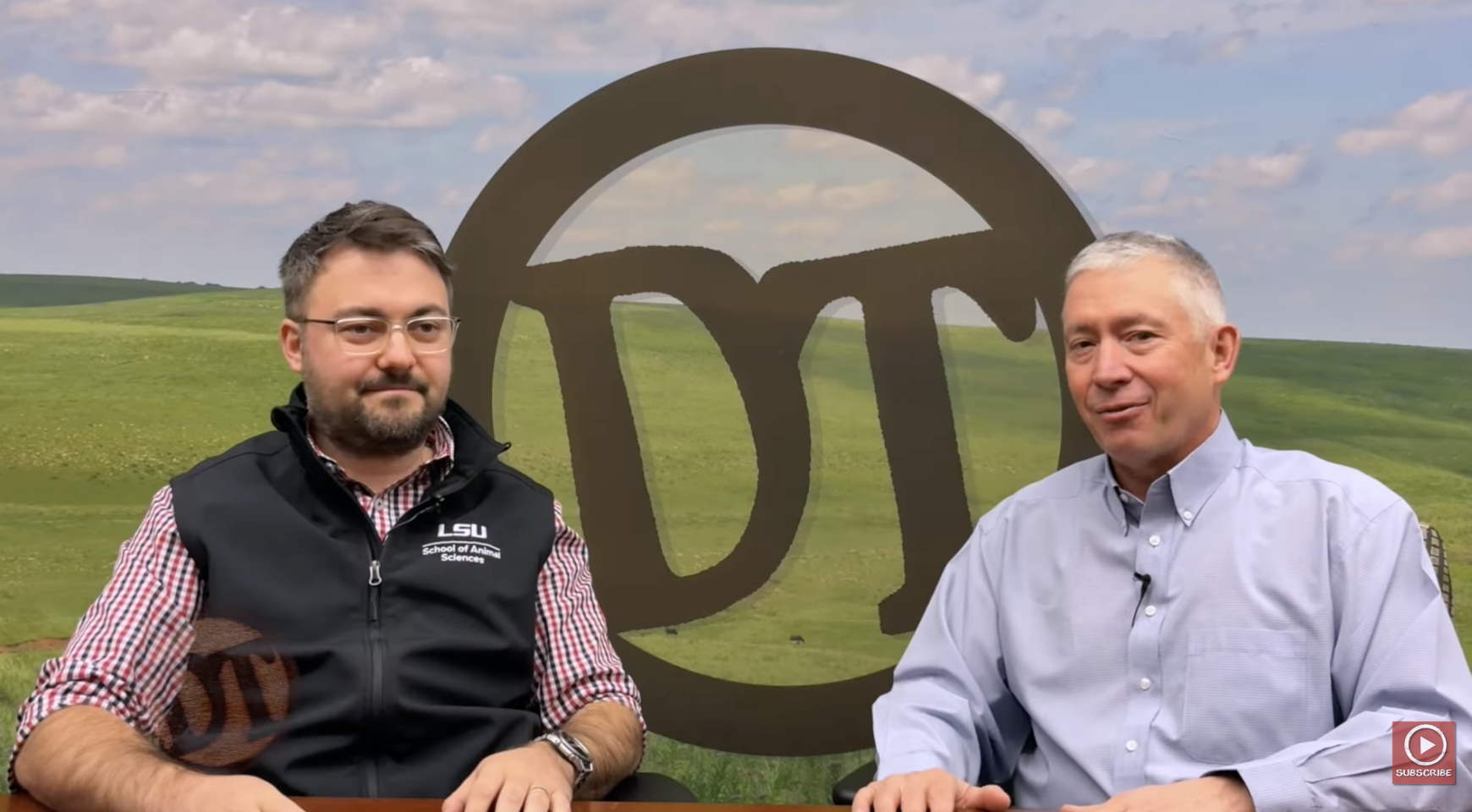 Two researchers speaking in front of an LSU logo