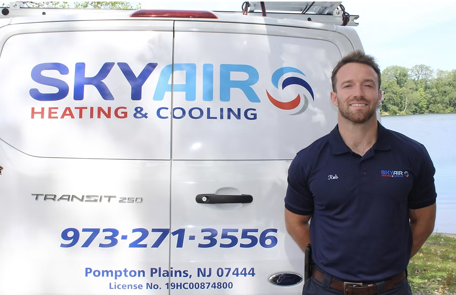 Rob, owner of Sky Air Heating & Cooling, standing next to his branded Sky Air service van in Pompton Plains, NJ