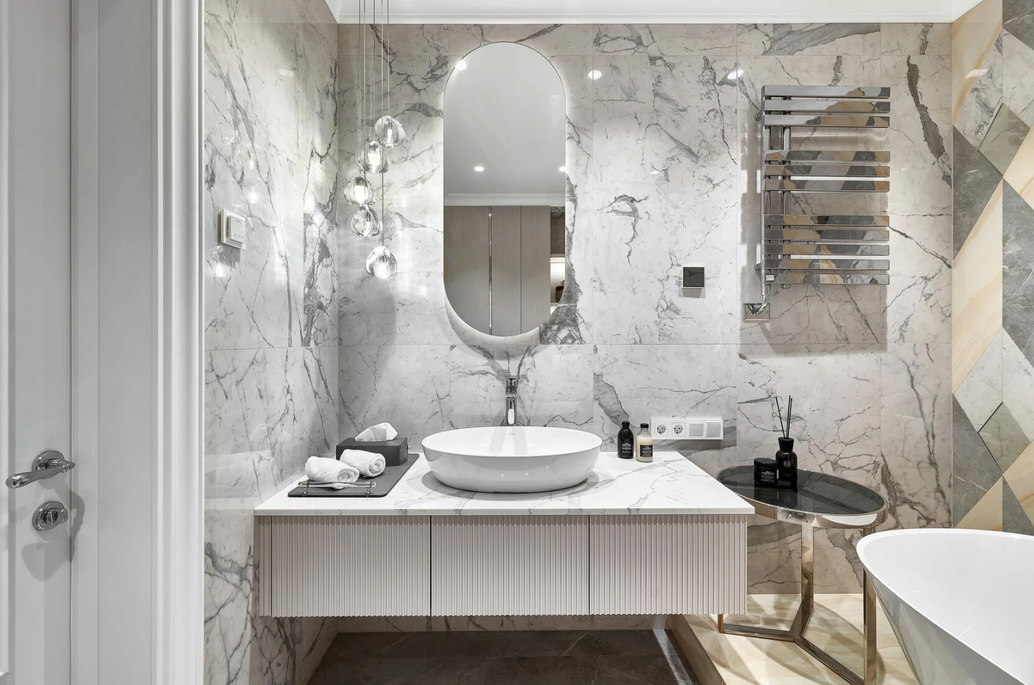 White Carrara marble bathroom with oval mirror and vessel sink