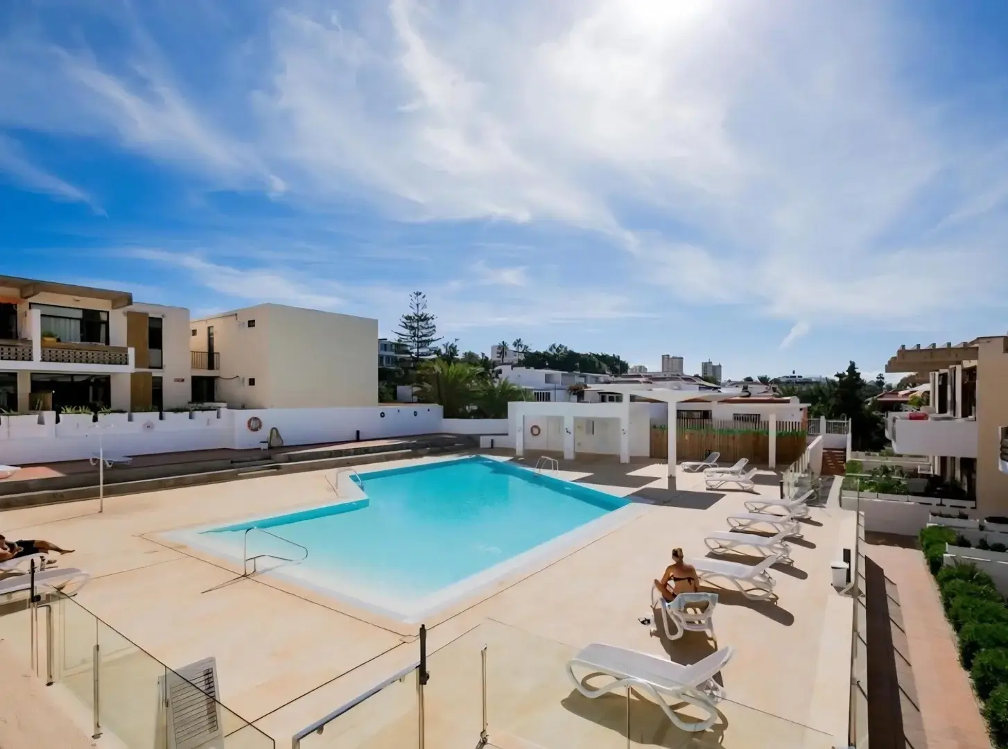 Pool area with loungers and blue sky