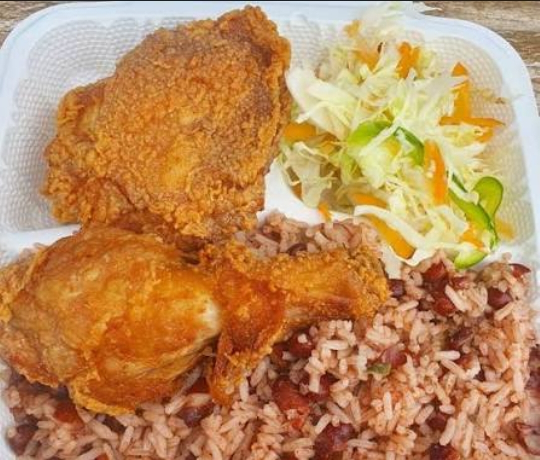 Jamaican plate with fried chicken, rice and peas, and salad