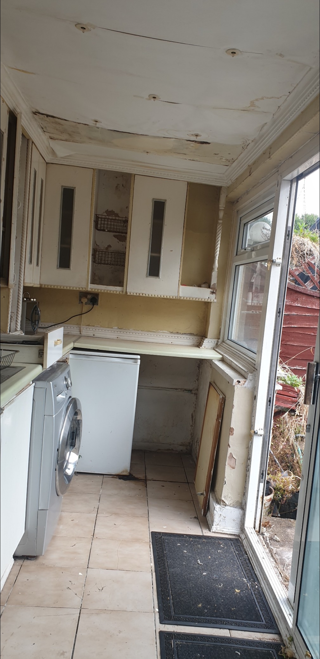 Kitchen before renovation - damaged ceiling and old cabinets