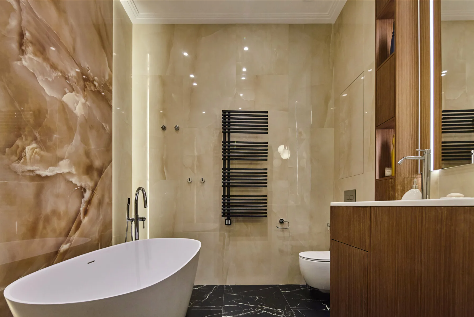 Luxury bathroom with onyx walls, freestanding white tub and wood vanity