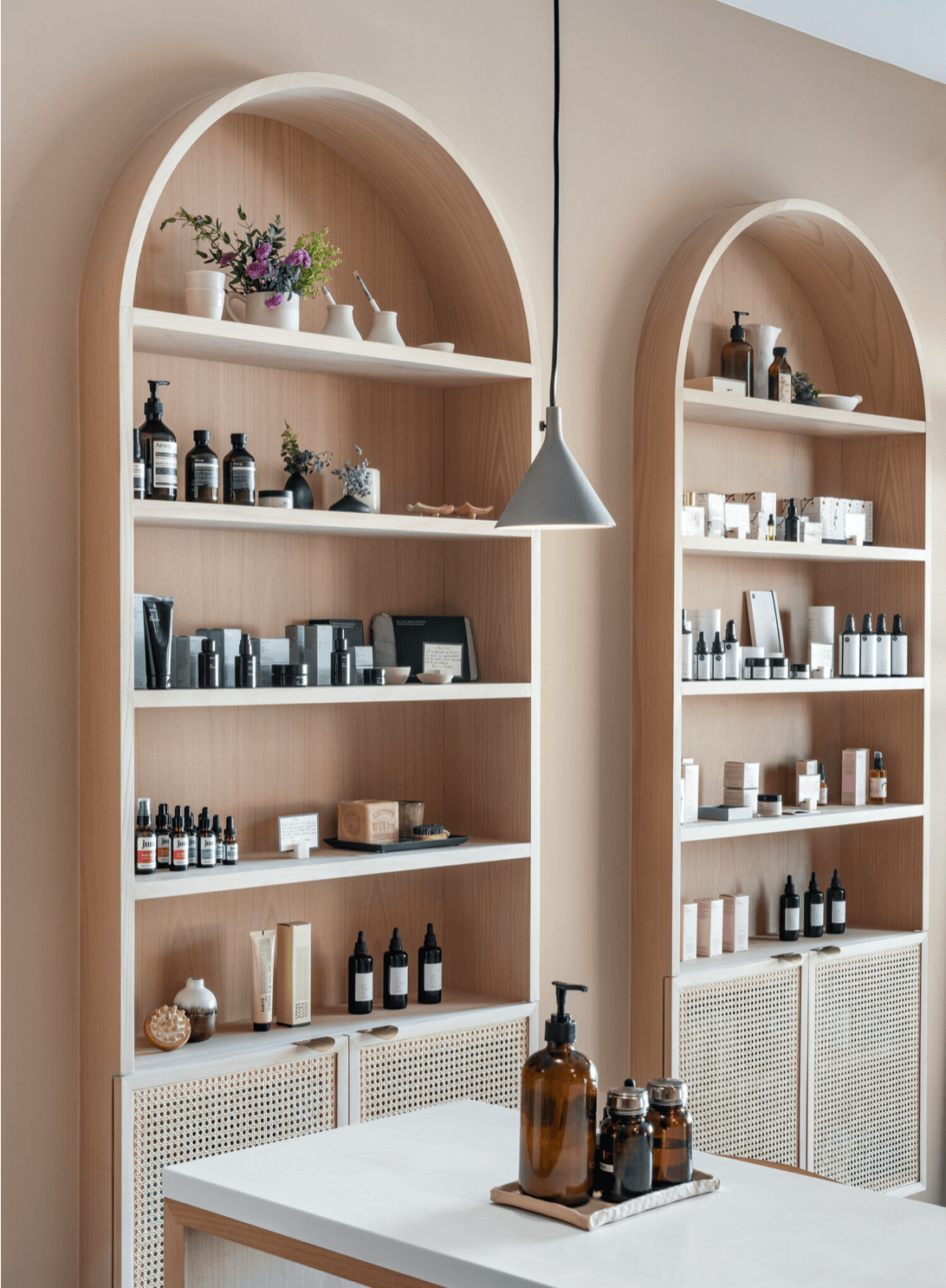 Detail of arched shelving unit with organized product display and pendant lighting