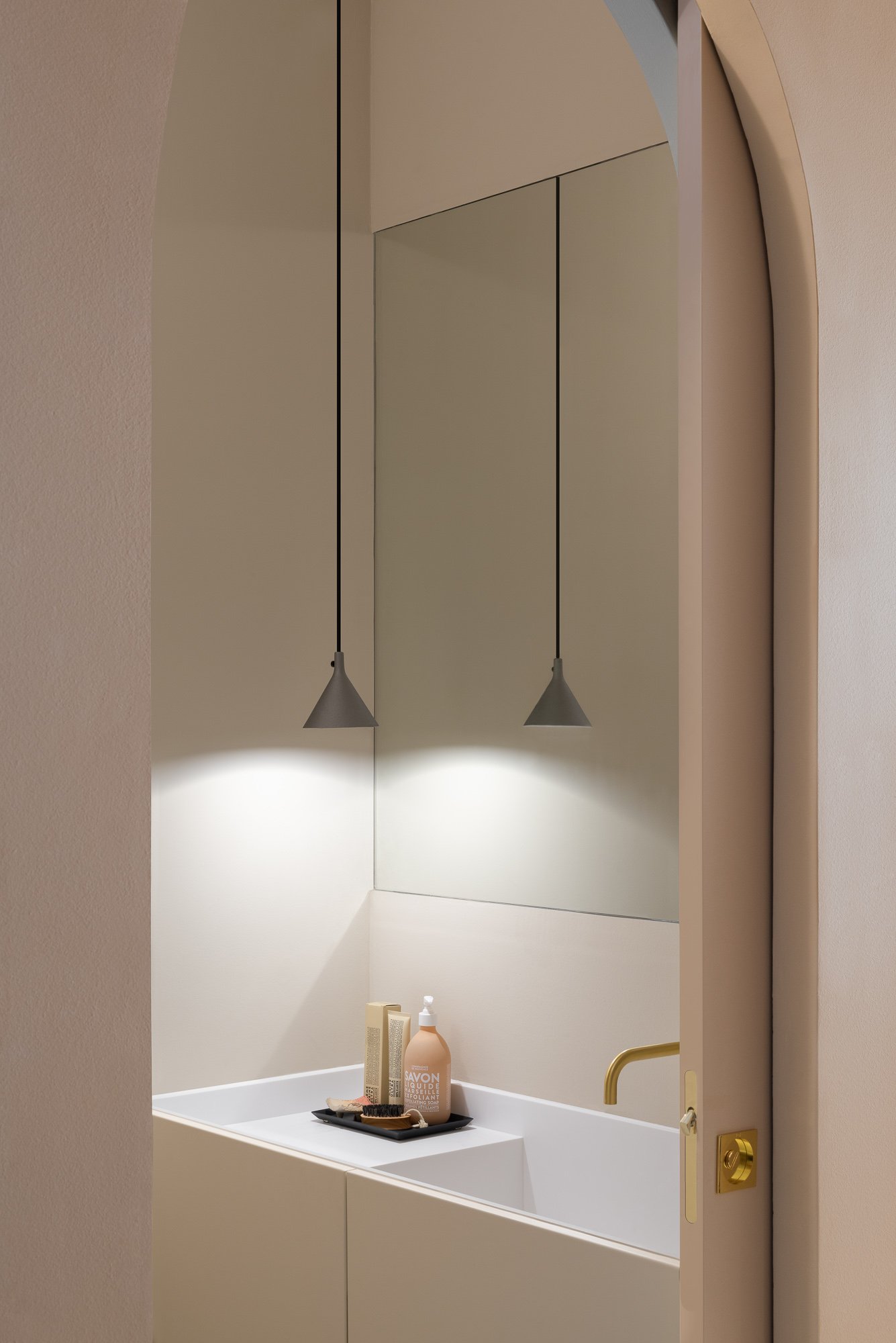 Minimalist bathroom detail with pendant lights and brass fixtures