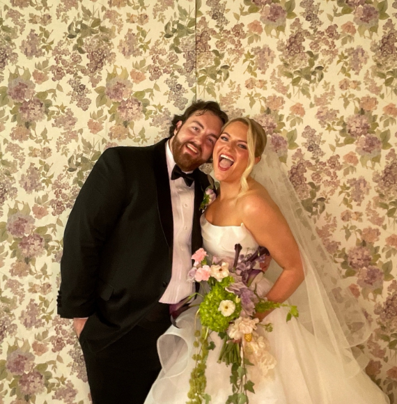 Bride and groom at floral wallpaper backdrop Nashville wedding photobooth