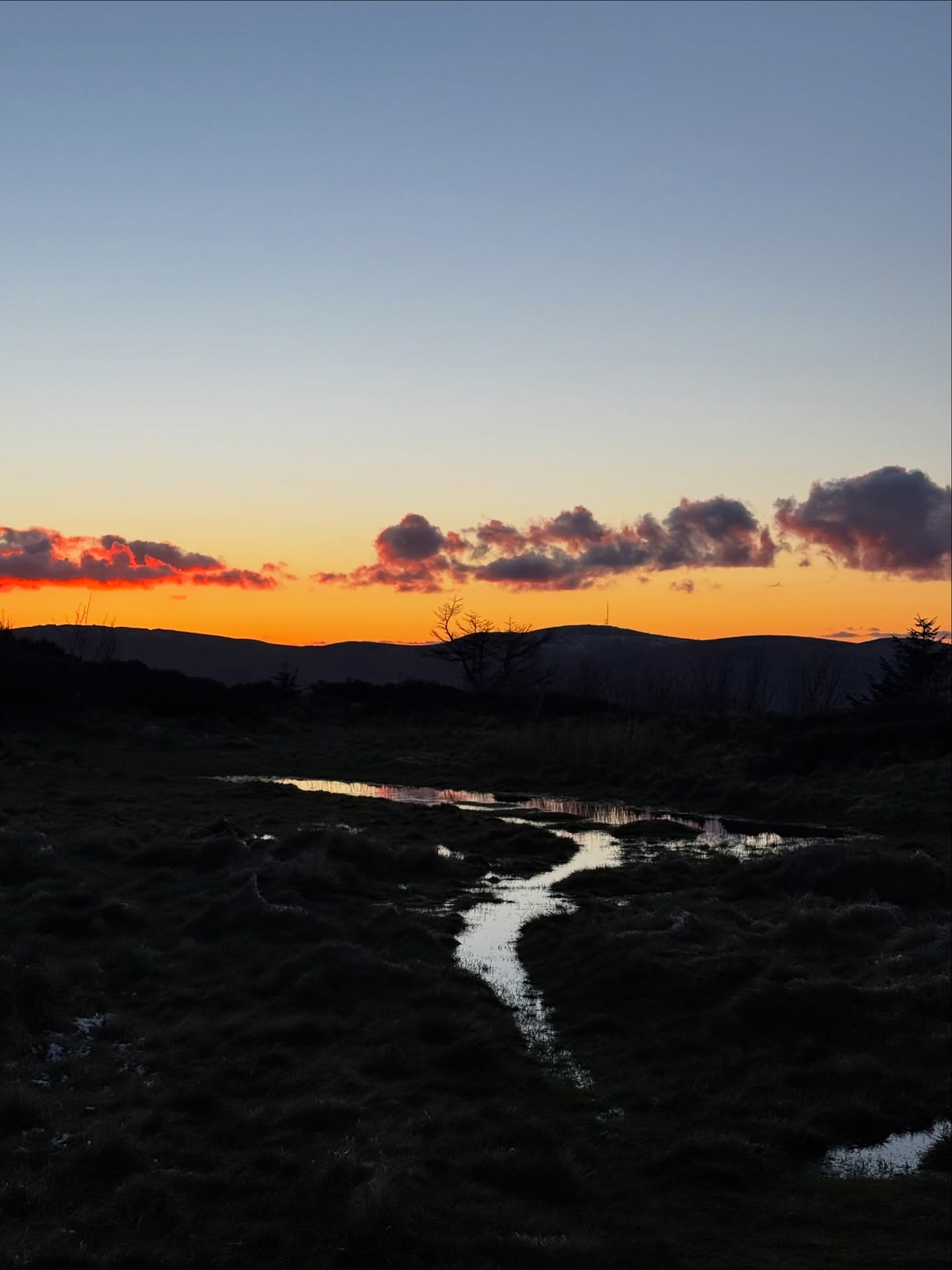 Dramatic sunset over Irish moorland with reflecting stream