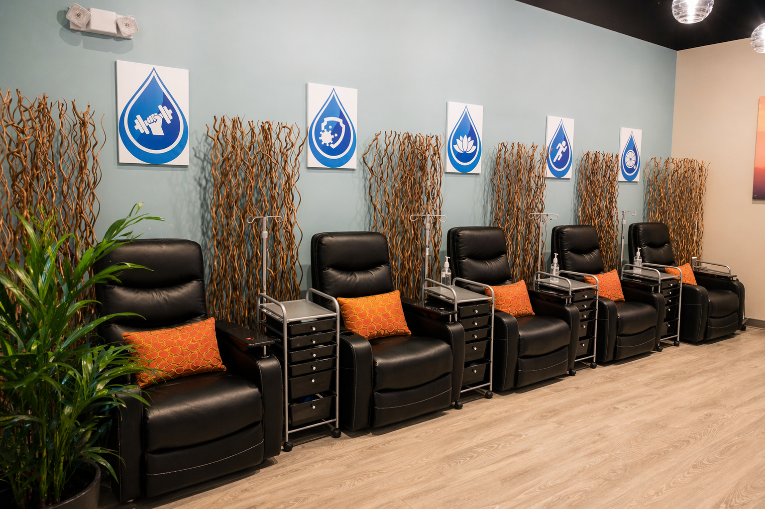 Row of black leather reclining chairs with orange pillows in the IV therapy lounge