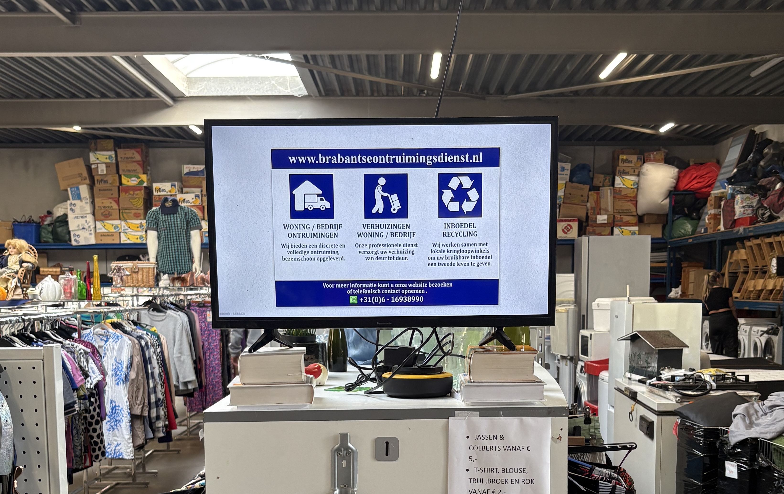 TV-scherm in kringloopwinkel Henkies met advertentie