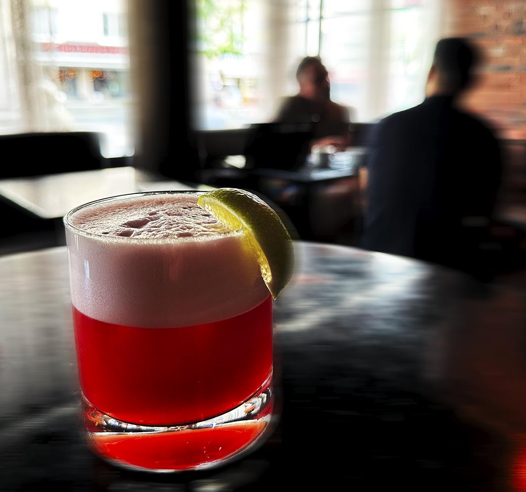 Red cocktail with lime