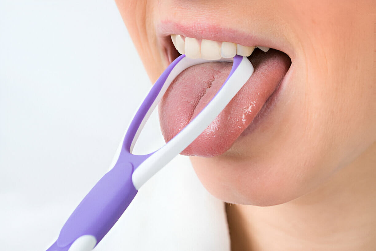 Person using a purple tongue scraper for a cleaner, fresher mouth