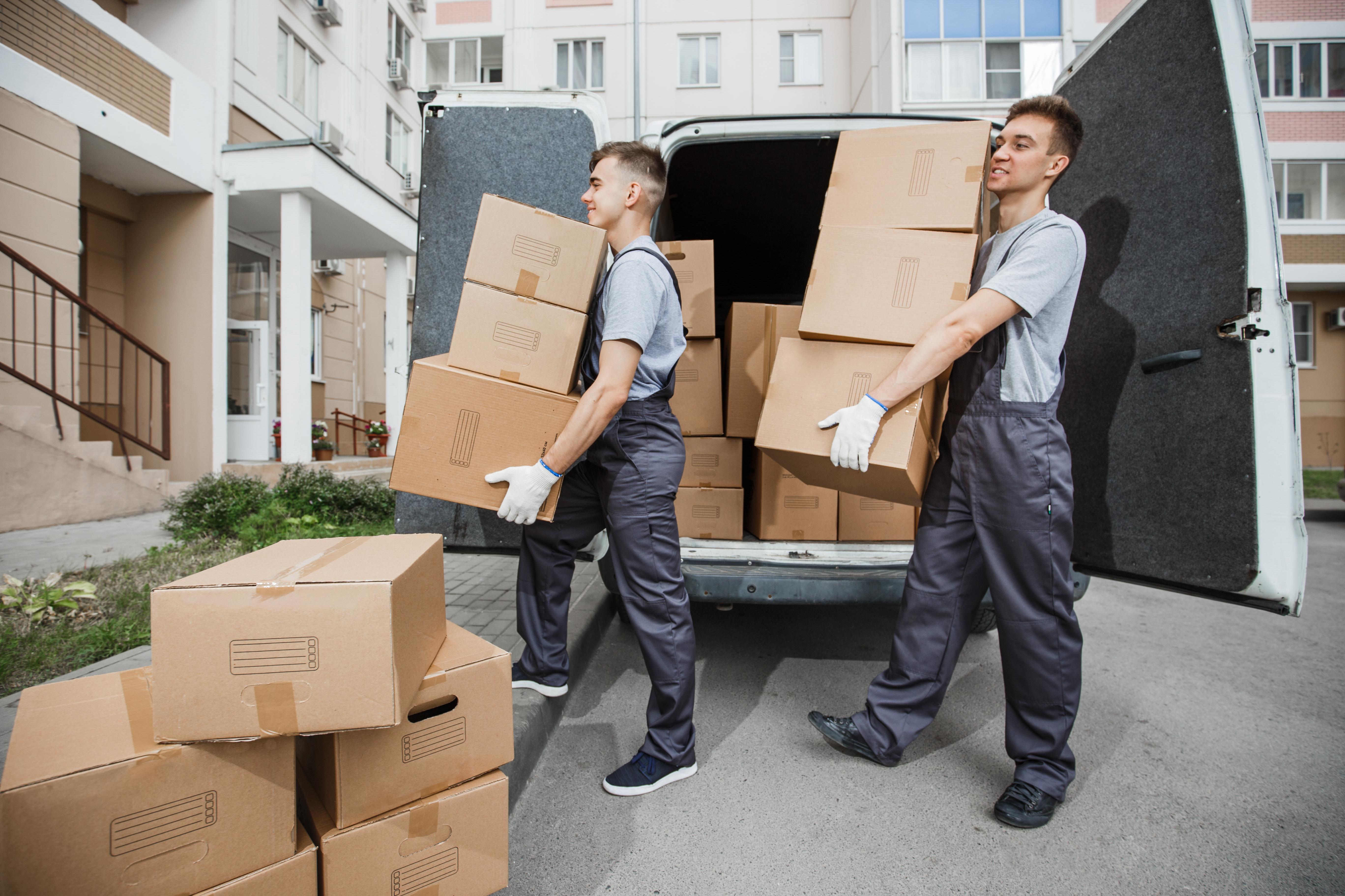 Zwei Umzugshelfer entladen Kartons vom Transporter – Umzug Berlin-Treptow