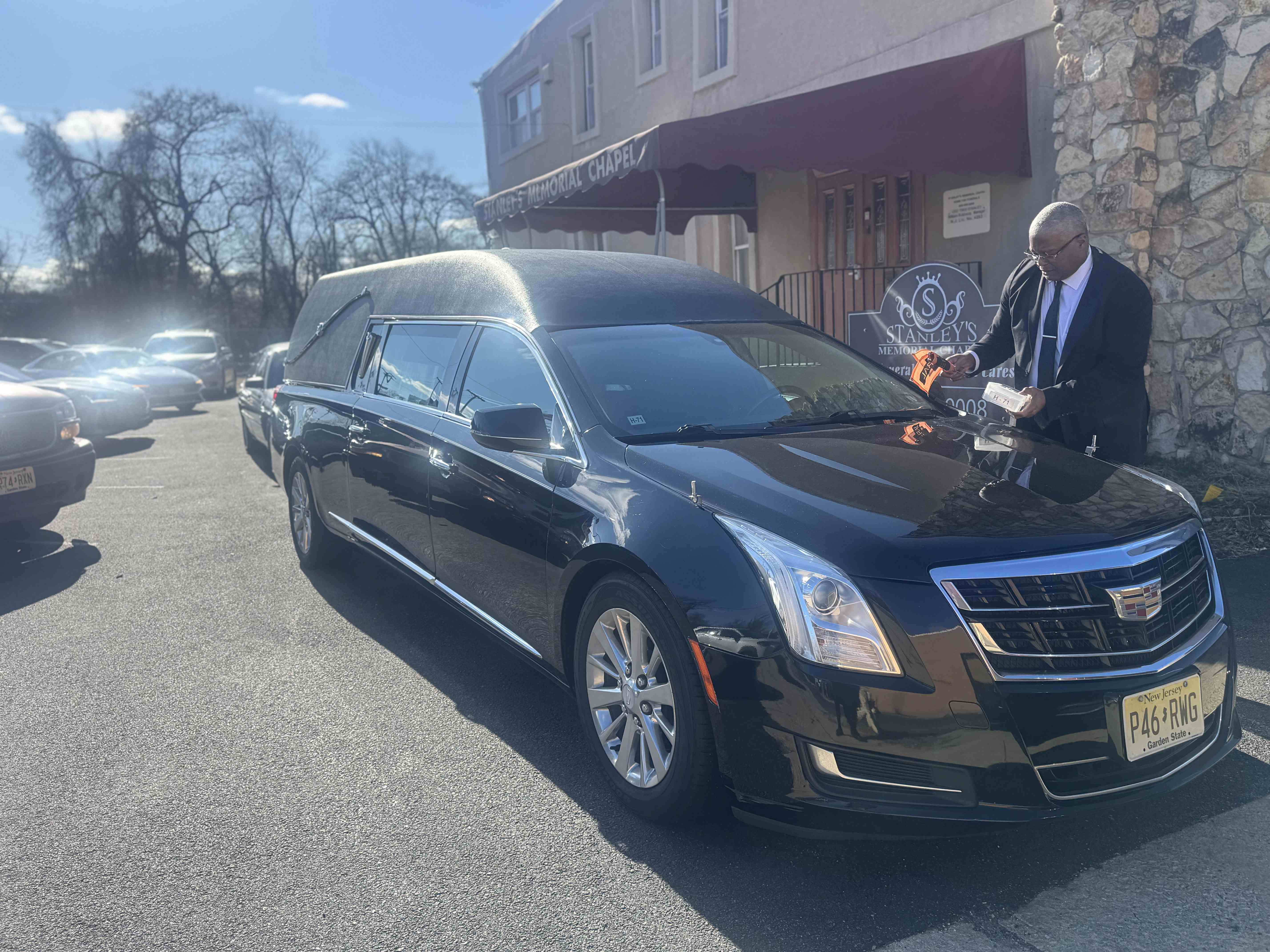 Funeral director with hearse at Stanley's Memorial Chapel