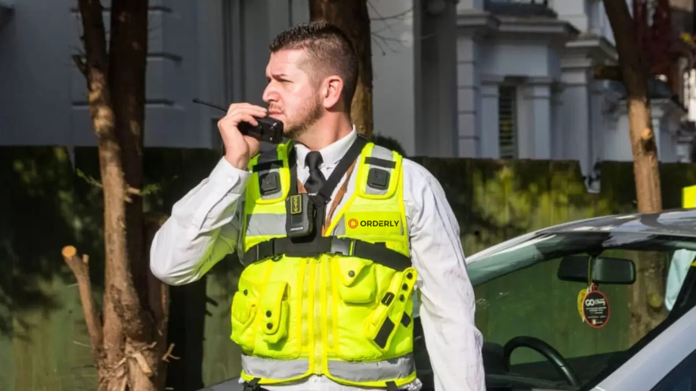 Professional Orderly security guard in high-visibility vest with radio communication