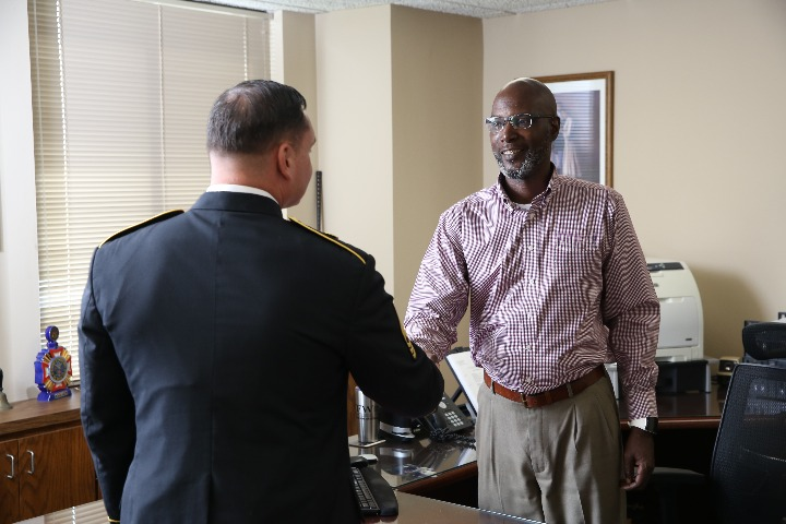 A VFW Foundation representative shaking hands with a uniformed military officer in an office