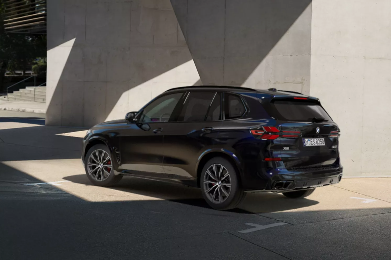 Dark navy BMW X5 SUV parked in a modern architectural setting